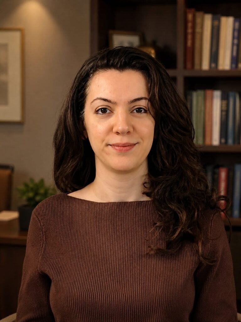 Home Foto da psicanalista Dra. Sara Panjeh em seu consultório, sorrindo e pronta para atendimento.